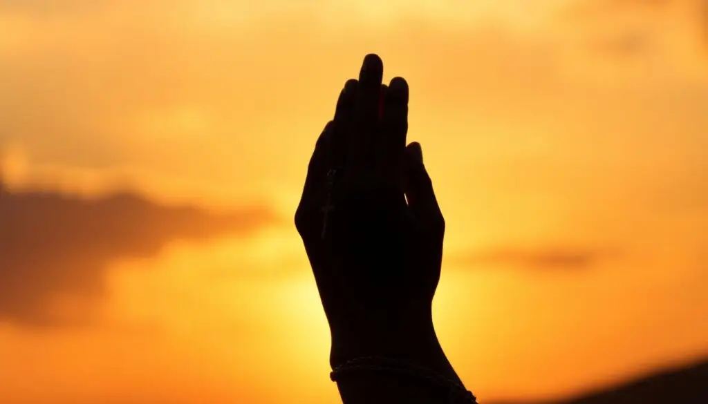 Osoba trzymająca różaniec na tle zachodzącego słońca - tajemnice różańca świętego ściąga