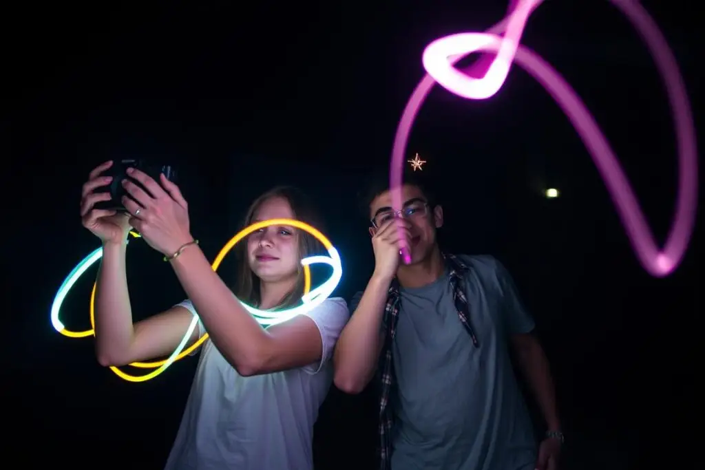 Przyjaciółki robiące nocne zdjęcia z użyciem świateł i długiego czasu naświetlania