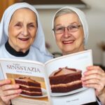 Siostra Anastazja z książką kucharską zawierającą przepis na ciasto snikers na biszkopcie