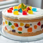 Śmietanowiec z galaretką siostry Anastazji na paterze, udekorowany kolorowymi galaretkami i owocami