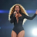 Beyoncé na scenie w charakterystycznym kostiumie scenicznym, mikrofon w ręce