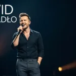 Portret Dawida Podsiadłego, polskiego piosenkarza, stojący przed mikrofonem