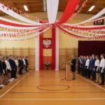 Scenariusz akademii 11 listopada - udekorowana sala gimnastyczna szkoły z biało-czerwonymi flagami i uczniami podczas uroczystości